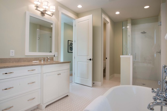На фото: главная ванная комната в классическом стиле с накладной раковиной, белыми фасадами, столешницей из известняка, отдельно стоящей ванной, угловым душем, керамогранитной плиткой и полом из керамогранита с