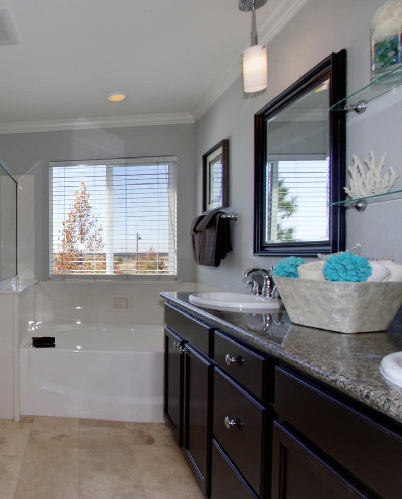 Example of a classic beige tile and stone slab freestanding bathtub design in Sacramento with a drop-in sink, flat-panel cabinets, dark wood cabinets and granite countertops