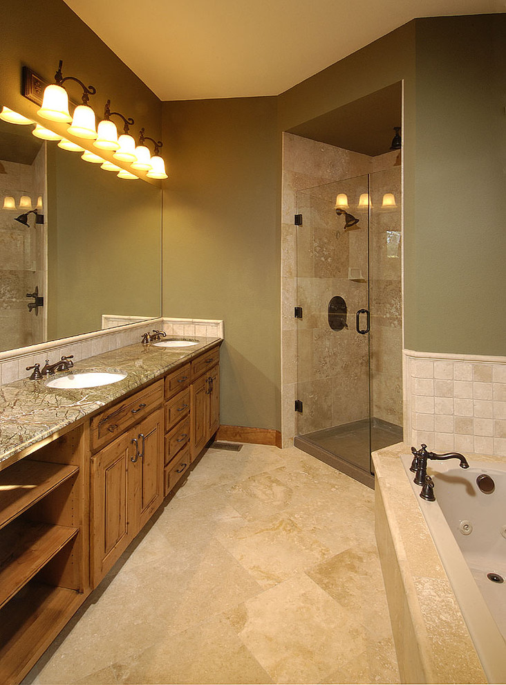 Design ideas for a medium sized rustic ensuite bathroom in Denver with beaded cabinets, medium wood cabinets, an alcove bath, an alcove shower, beige tiles, stone tiles, green walls, limestone flooring, a submerged sink and granite worktops.