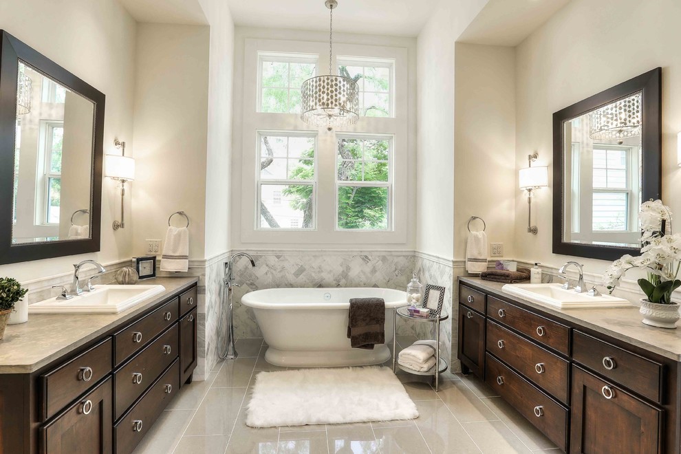 オースティンにあるトラディショナルスタイルのおしゃれな浴室 (濃色木目調キャビネット、置き型浴槽、グレーのタイル、白い壁、オーバーカウンターシンク、シェーカースタイル扉のキャビネット) の写真