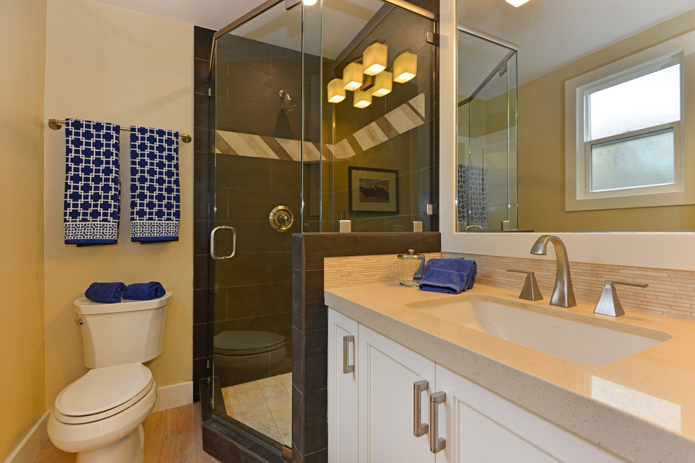 Small beach style 3/4 brown tile and ceramic tile light wood floor corner shower photo in San Diego with an undermount sink, shaker cabinets, white cabinets, quartzite countertops, a one-piece toilet and beige walls