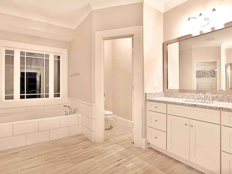 Exempel på ett mellanstort modernt en-suite badrum, med skåp i shakerstil, vita skåp, ett platsbyggt badkar, en dusch i en alkov, en toalettstol med separat cisternkåpa, grå kakel, keramikplattor, grå väggar, klinkergolv i keramik, ett undermonterad handfat och granitbänkskiva