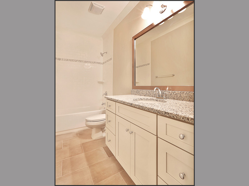 Design ideas for a medium sized traditional bathroom in Atlanta with shaker cabinets, white cabinets, a built-in bath, an alcove shower, a two-piece toilet, grey tiles, ceramic tiles, grey walls, ceramic flooring, a submerged sink and granite worktops.