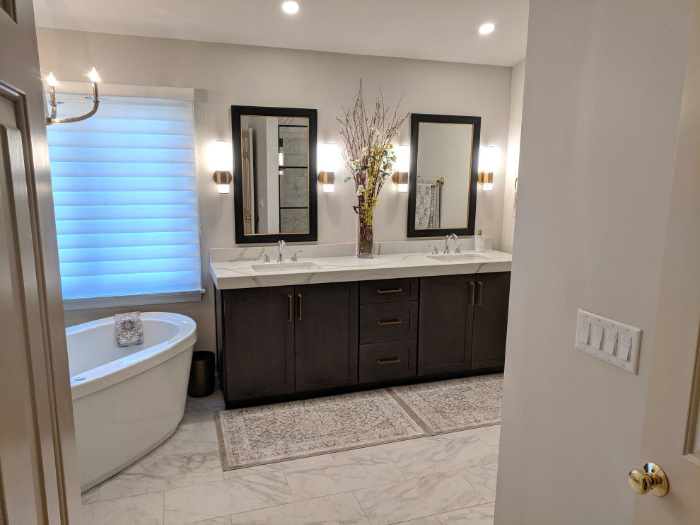 Inspiration for a mid-sized transitional master white tile marble floor, gray floor and double-sink bathroom remodel in Cleveland with recessed-panel cabinets, brown cabinets, a two-piece toilet, gray walls, an undermount sink, quartz countertops, white countertops and a freestanding vanity