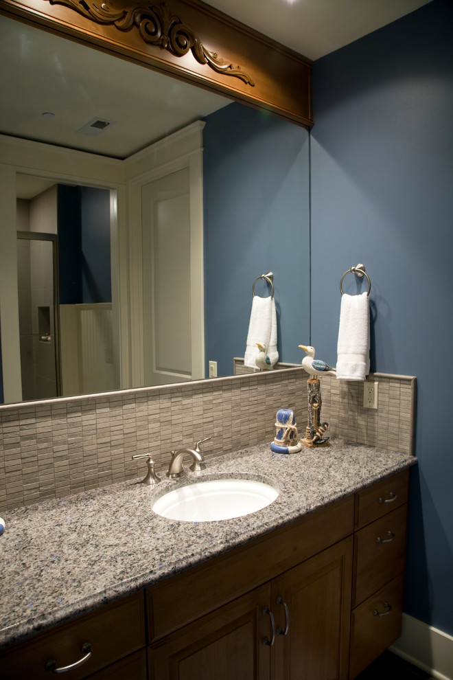 Bild på ett mellanstort amerikanskt beige beige badrum med dusch, med luckor med upphöjd panel, skåp i mellenmörkt trä, beige kakel, stenkakel, blå väggar, ett undermonterad handfat och granitbänkskiva
