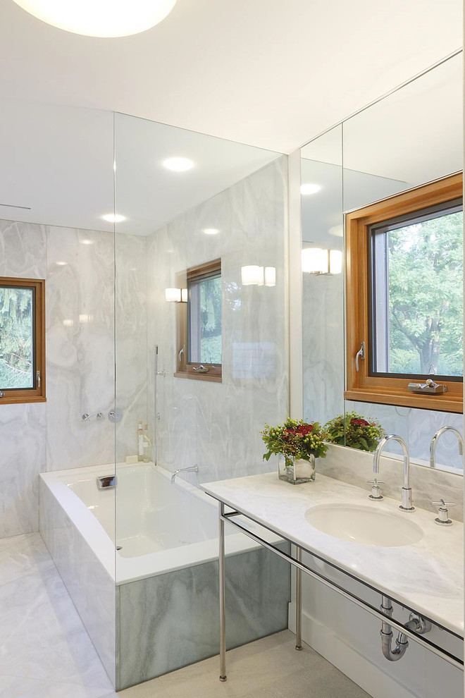 ニューヨークにあるコンテンポラリースタイルのおしゃれな浴室 (コンソール型シンク、白いタイル、石スラブタイル、アンダーマウント型浴槽) の写真