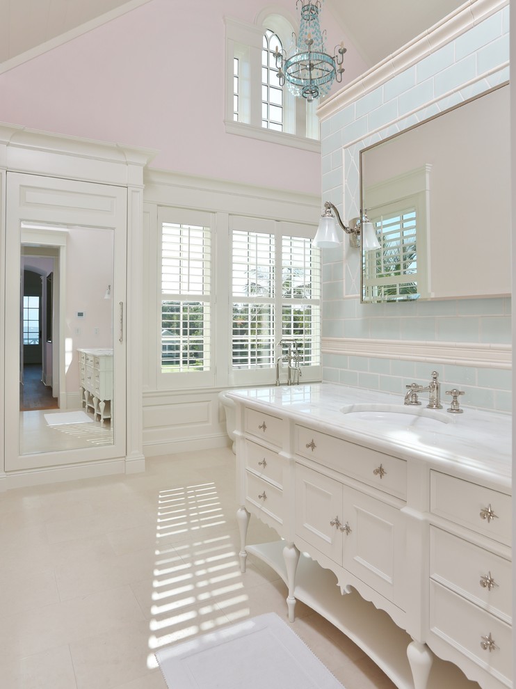 Стильный дизайн: большая главная ванная комната в классическом стиле с фасадами с декоративным кантом, белыми фасадами, отдельно стоящей ванной, открытым душем, синей плиткой, розовыми стенами, полом из травертина, врезной раковиной и мраморной столешницей - последний тренд