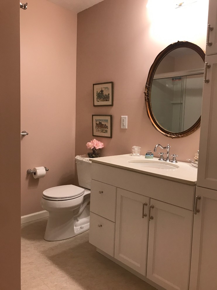 Стильный дизайн: маленькая главная ванная комната в классическом стиле с плоскими фасадами, белыми фасадами, душем в нише, раздельным унитазом, розовой плиткой, розовыми стенами, полом из линолеума, врезной раковиной, столешницей из искусственного камня, бежевым полом и душем с раздвижными дверями для на участке и в саду - последний тренд