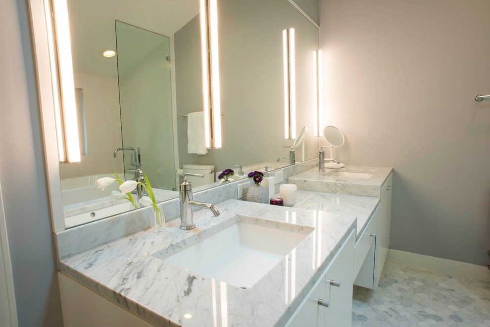 Aménagement d'une salle de bain principale moderne de taille moyenne avec un lavabo encastré, un placard à porte plane, des portes de placard blanches, un plan de toilette en marbre, une baignoire indépendante, une douche ouverte, WC à poser, un carrelage gris, un mur gris et un sol en marbre.