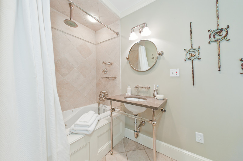 Medium sized classic ensuite bathroom in Boston with a built-in bath, a shower/bath combination, pink tiles, cement tiles, grey walls, cement flooring, a submerged sink and a shower curtain.