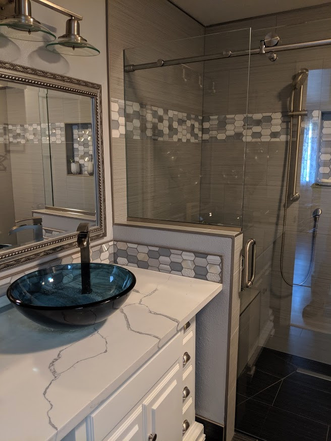 This is an example of a medium sized classic shower room bathroom in Seattle with freestanding cabinets, white cabinets, a built-in shower, grey tiles, ceramic tiles, grey walls, ceramic flooring, a vessel sink, quartz worktops, black floors, a sliding door and white worktops.