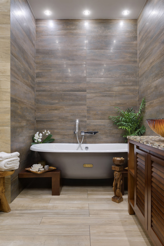Bild på ett mellanstort funkis beige beige en-suite badrum, med en jacuzzi, en hörndusch, en toalettstol med hel cisternkåpa, beige kakel, keramikplattor, beige väggar, cementgolv, bänkskiva i glas, beiget golv och dusch med skjutdörr