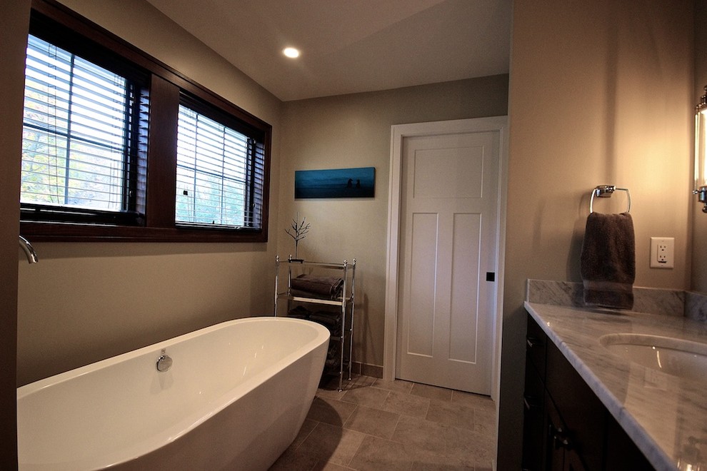 Small traditional ensuite bathroom in Detroit with flat-panel cabinets, dark wood cabinets, a freestanding bath, a one-piece toilet, white tiles, beige walls, concrete flooring, a submerged sink and soapstone worktops.