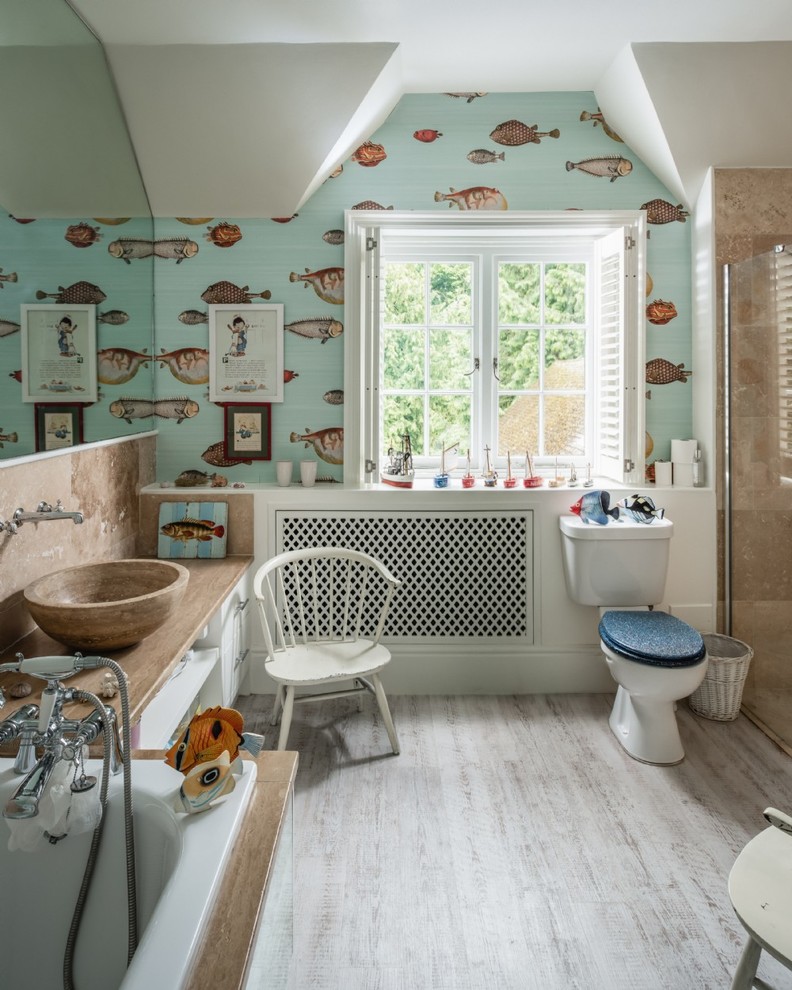 Medium sized bohemian bathroom in Hampshire with a two-piece toilet, a vessel sink, white cabinets, a built-in bath, multi-coloured walls, beige floors and beige worktops.