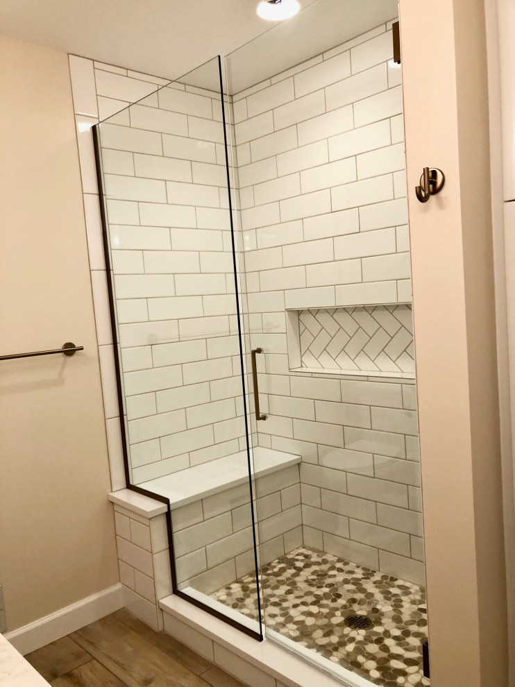 Photo of a small classic ensuite bathroom in Detroit with shaker cabinets, white cabinets, an alcove shower, a two-piece toilet, white tiles, metro tiles, pink walls, wood-effect flooring, a submerged sink, engineered stone worktops, beige floors, a hinged door, white worktops, a shower bench, double sinks and a built in vanity unit.