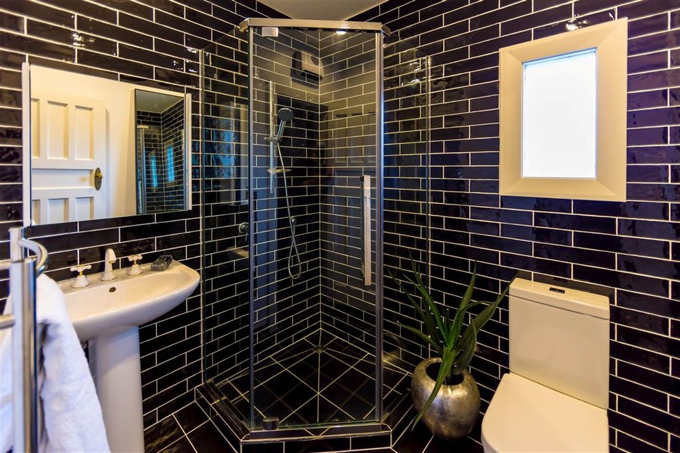 Exempel på ett klassiskt badrum, med en hörndusch, en toalettstol med hel cisternkåpa, svart kakel, keramikplattor, svarta väggar, klinkergolv i keramik och ett piedestal handfat