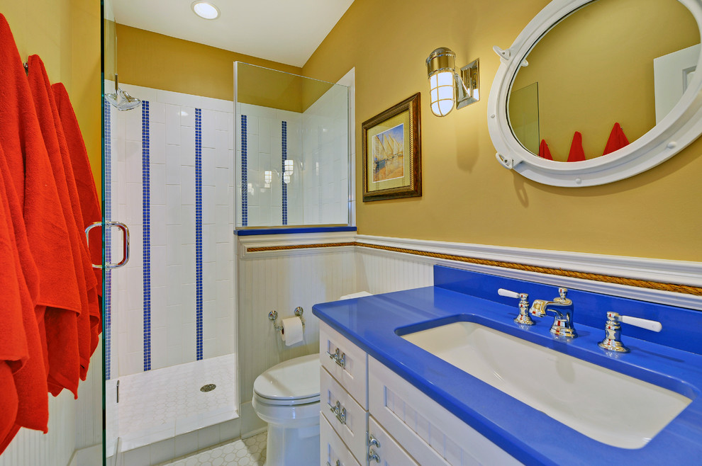 Cette image montre une douche en alcôve marine avec un lavabo encastré, un placard avec porte à panneau encastré, des portes de placard blanches et un carrelage blanc.