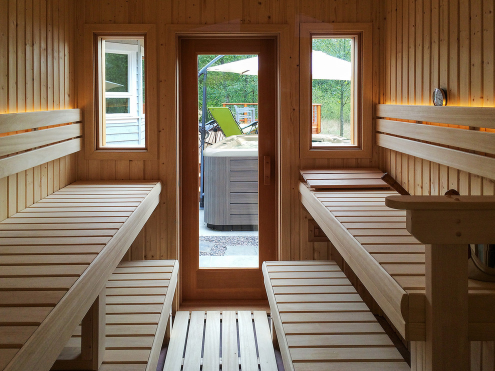 Ejemplo de sauna actual de tamaño medio sin sin inodoro con baldosas y/o azulejos blancos, baldosas y/o azulejos de cerámica, paredes grises y suelo de madera en tonos medios