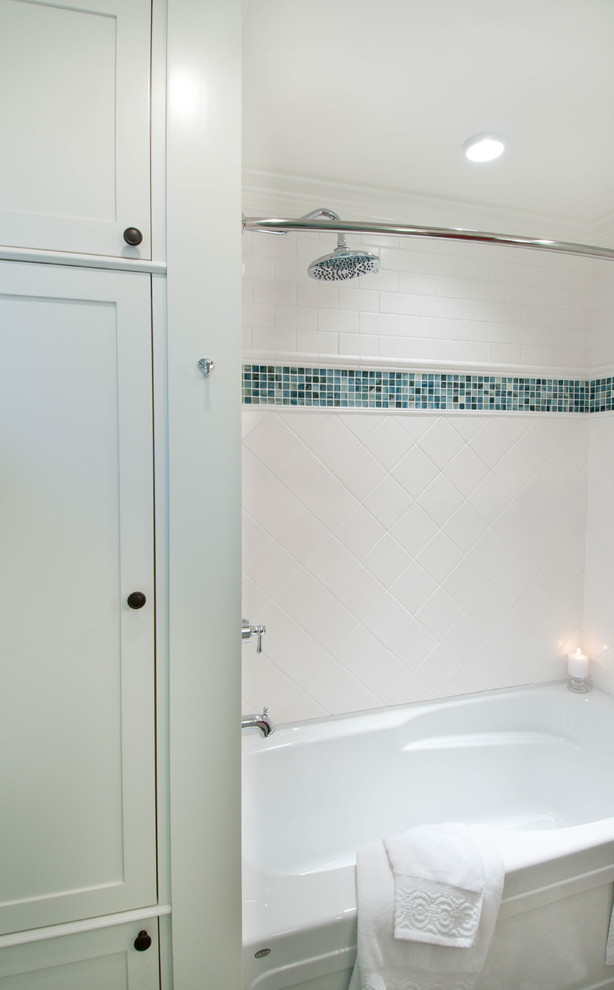 Esempio di una piccola stanza da bagno american style con lavabo sottopiano, consolle stile comò, ante bianche, vasca ad alcova, vasca/doccia, WC a due pezzi, piastrelle multicolore, pareti blu e pavimento con piastrelle a mosaico