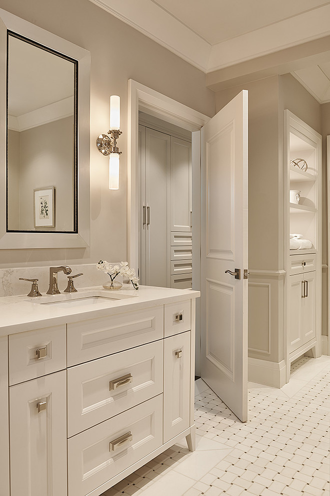 Aménagement d'une salle de bain principale classique de taille moyenne avec un placard avec porte à panneau encastré, des portes de placard blanches, une baignoire indépendante, un mur gris, un lavabo encastré, un plan de toilette en quartz modifié, un sol blanc et un plan de toilette blanc.