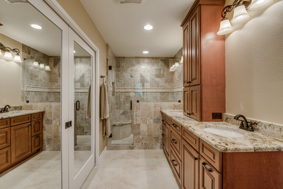 Medium sized traditional ensuite bathroom in Austin with shaker cabinets, brown cabinets, an alcove shower, a one-piece toilet, beige tiles, porcelain tiles, beige walls, ceramic flooring, a built-in sink, granite worktops, beige floors, a hinged door and beige worktops.