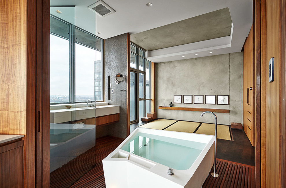 Idee per una stanza da bagno padronale etnica con ante lisce, ante in legno scuro, vasca giapponese, pareti grigie, pavimento in legno massello medio e pavimento marrone
