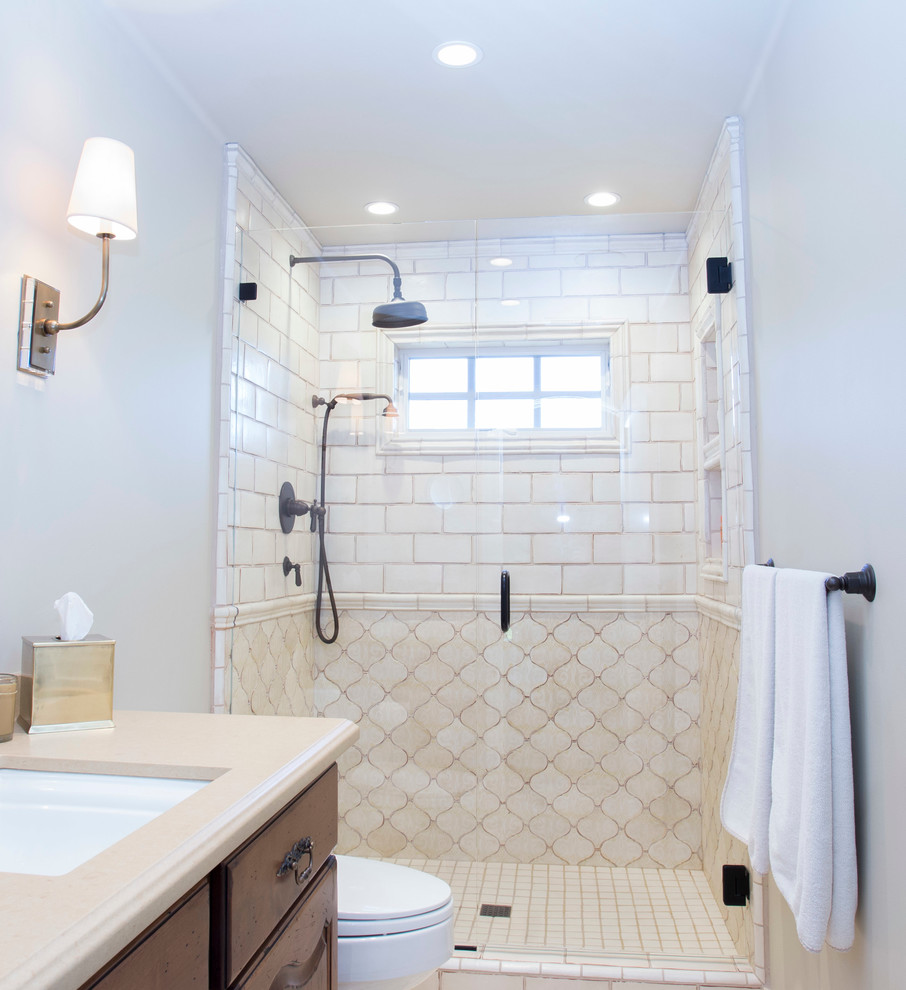 Medium sized mediterranean shower room bathroom in San Francisco with raised-panel cabinets, dark wood cabinets, an alcove shower, a two-piece toilet, beige tiles, ceramic tiles, grey walls, a submerged sink, engineered stone worktops and a hinged door.