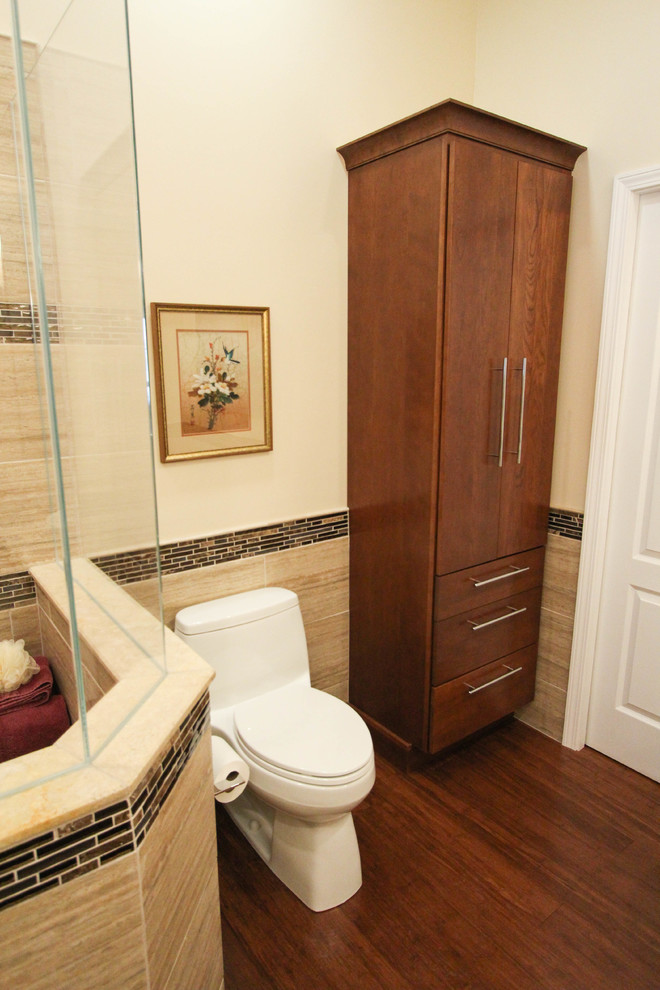 Inspiration pour une salle de bain design en bois foncé avec une vasque, un placard à porte plane, un plan de toilette en granite, une baignoire indépendante, une douche d'angle, WC à poser, un carrelage beige et des carreaux de porcelaine.