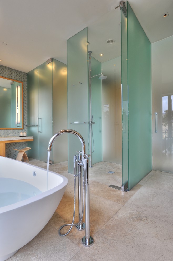 Immagine di una stanza da bagno minimal con vasca freestanding, piastrelle blu, piastrelle a mosaico e pavimento in travertino