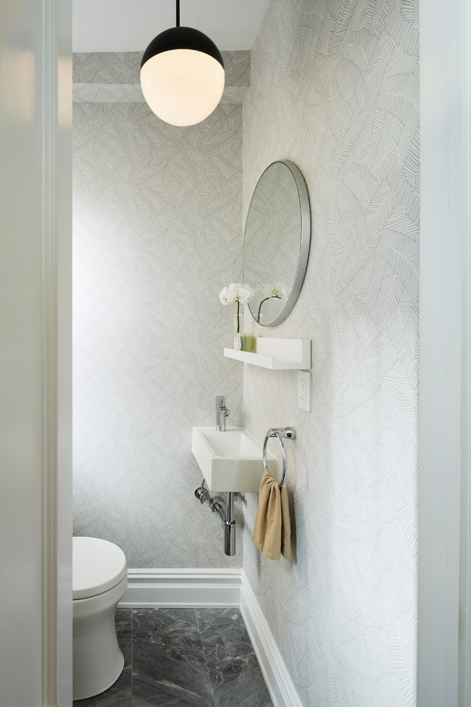 Esempio di un piccolo bagno di servizio minimalista con WC monopezzo, piastrelle blu, piastrelle in pietra, pareti grigie, pavimento in marmo e lavabo sospeso