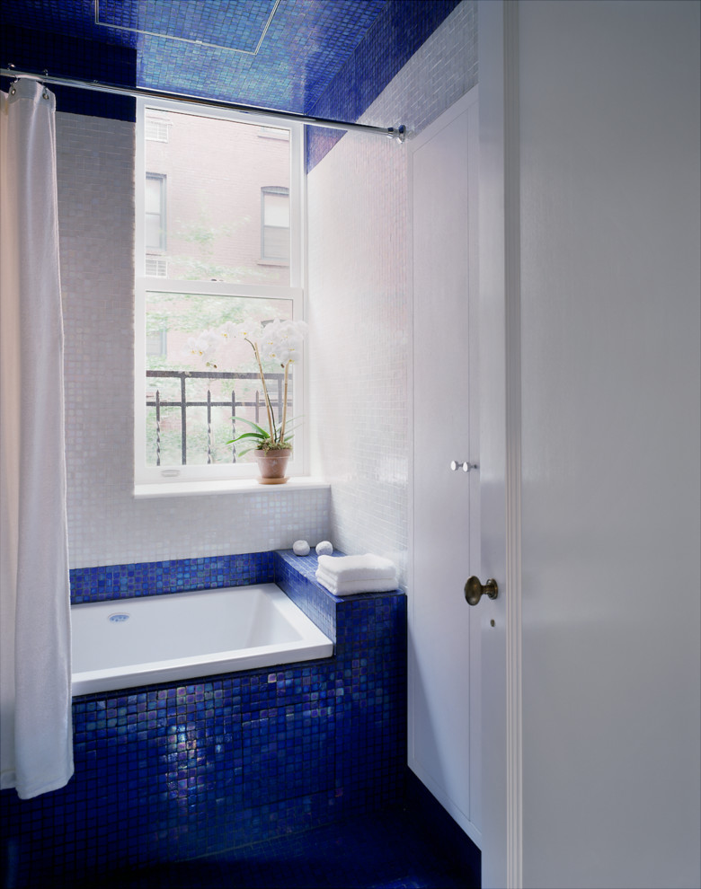 Ejemplo de cuarto de baño infantil minimalista pequeño con lavabo tipo consola, bañera encastrada, combinación de ducha y bañera, sanitario de una pieza, baldosas y/o azulejos azules, baldosas y/o azulejos de vidrio y paredes multicolor