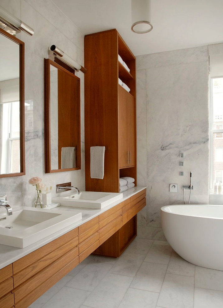 Источник вдохновения для домашнего уюта: главная ванная комната в современном стиле с фасадами цвета дерева среднего тона, отдельно стоящей ванной, белой плиткой, белыми стенами, белым полом, белой столешницей и зеркалом с подсветкой