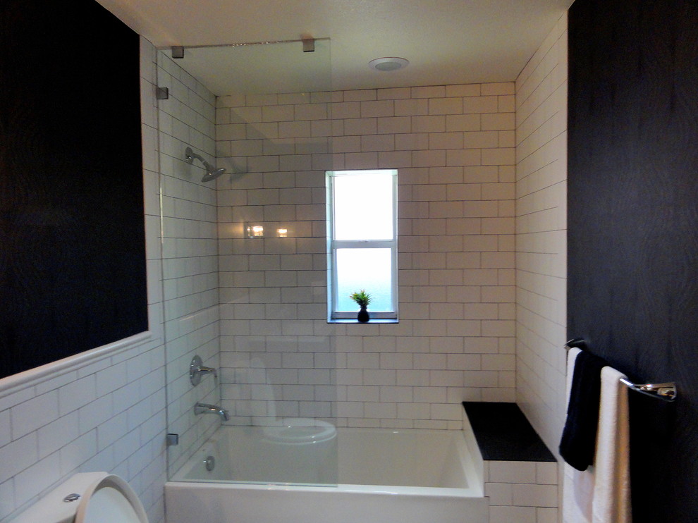 Mid-sized transitional white tile and ceramic tile slate floor bathroom photo in Miami with an integrated sink, medium tone wood cabinets, solid surface countertops, a two-piece toilet and black walls