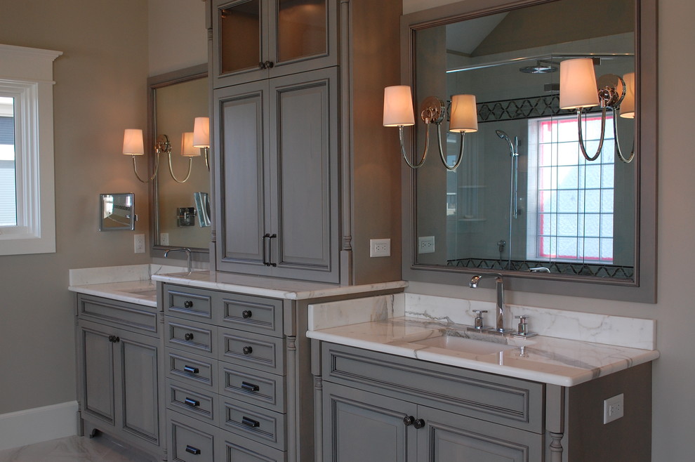 Diseño de cuarto de baño clásico con lavabo bajoencimera, armarios con paneles con relieve y puertas de armario grises