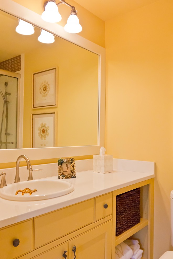 Foto di una piccola stanza da bagno con doccia tradizionale con ante gialle, piastrelle bianche, piastrelle di vetro, pareti gialle, lavabo da incasso e top in superficie solida