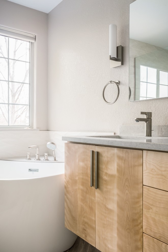 Inspiration for a medium sized contemporary ensuite bathroom in Denver with flat-panel cabinets, light wood cabinets, a freestanding bath, a corner shower, a one-piece toilet, white tiles, ceramic tiles, white walls, ceramic flooring, a submerged sink, engineered stone worktops, brown floors and an open shower.