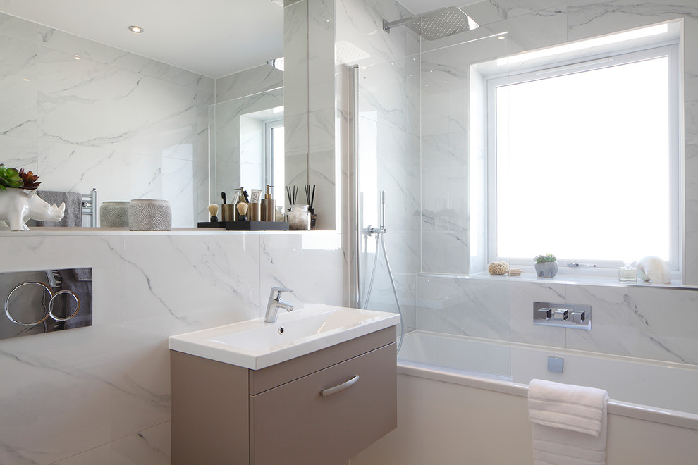 Design ideas for a small contemporary family bathroom in London with flat-panel cabinets, grey cabinets, a built-in bath, a shower/bath combination, white tiles, porcelain tiles, white walls, porcelain flooring, a wall-mounted sink and white floors.