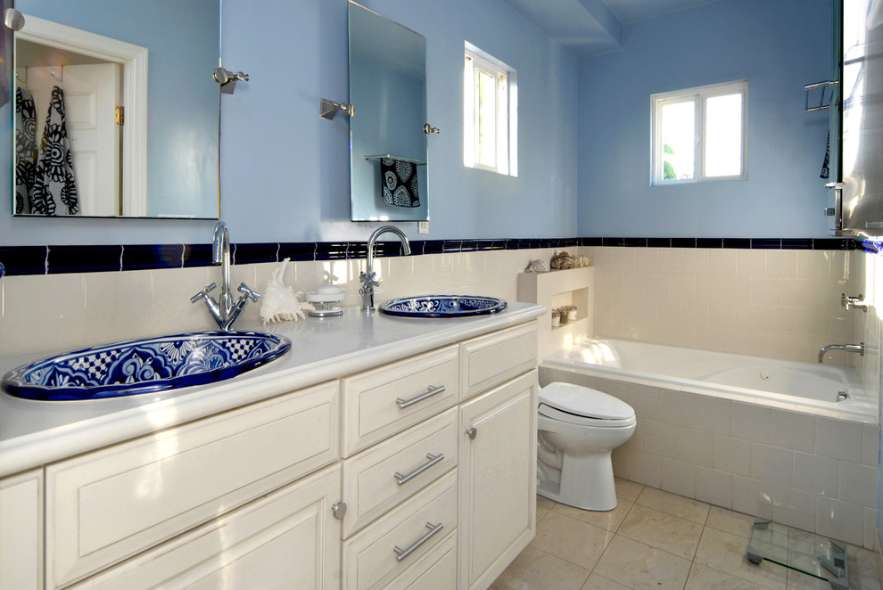 Mittelgroßes Mediterranes Badezimmer En Suite mit Einbauwaschbecken, profilierten Schrankfronten, weißen Schränken, Quarzwerkstein-Waschtisch, Einbaubadewanne, Toilette mit Aufsatzspülkasten, weißen Fliesen, Keramikfliesen, blauer Wandfarbe und Porzellan-Bodenfliesen in Los Angeles