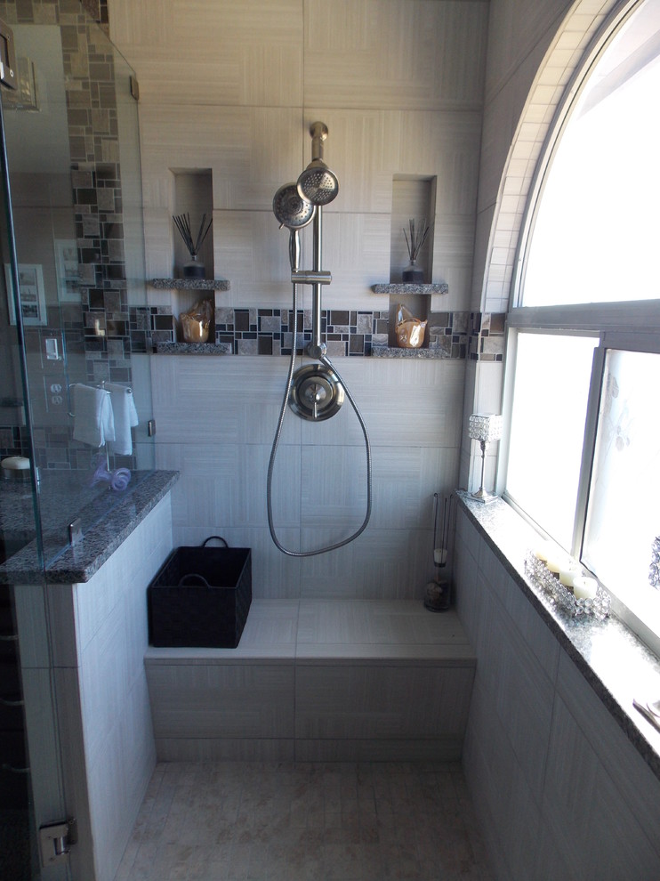 Modern inredning av ett mellanstort en-suite badrum, med luckor med infälld panel, skåp i mörkt trä, en hörndusch, en toalettstol med separat cisternkåpa, mosaik, grå väggar, ett undermonterad handfat, granitbänkskiva, grå kakel och klinkergolv i porslin