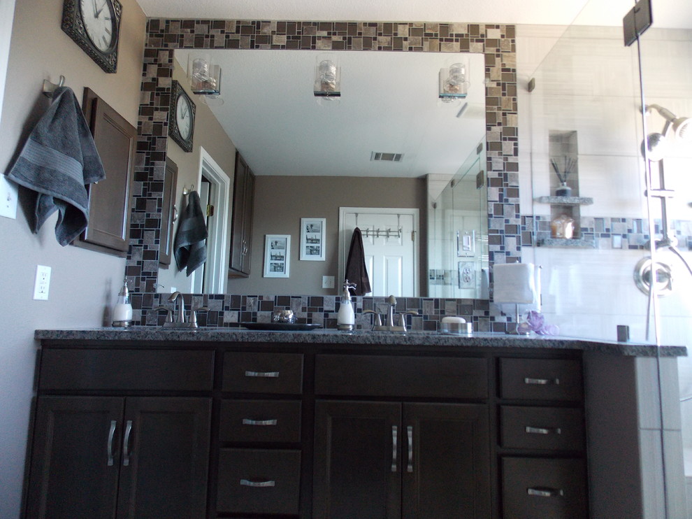 Exempel på ett mellanstort modernt en-suite badrum, med luckor med infälld panel, skåp i mörkt trä, en hörndusch, en toalettstol med separat cisternkåpa, mosaik, grå väggar, ett undermonterad handfat, granitbänkskiva, grå kakel och klinkergolv i porslin
