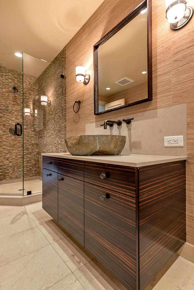 Inspiration for a mid-sized eclectic 3/4 beige tile and matchstick tile limestone floor corner shower remodel in San Francisco with a vessel sink, flat-panel cabinets, dark wood cabinets, limestone countertops, a two-piece toilet and brown walls