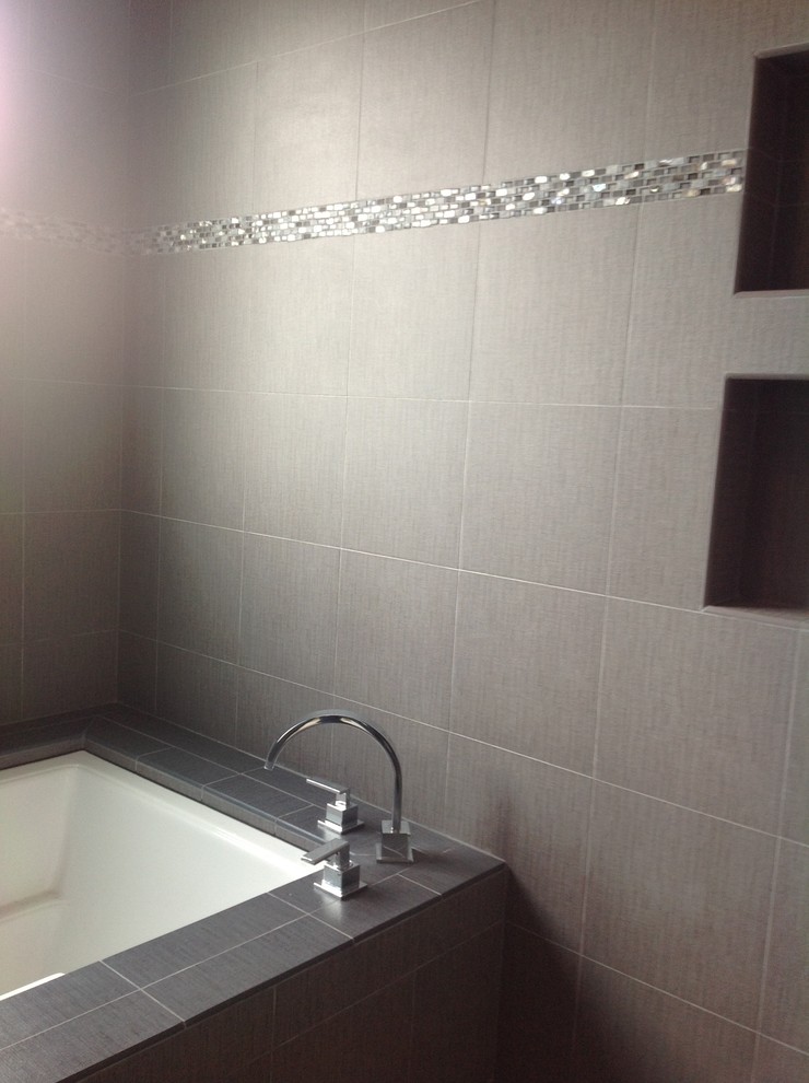 Esempio di una stanza da bagno minimalista con vasca ad alcova, vasca/doccia, piastrelle grigie e piastrelle in gres porcellanato