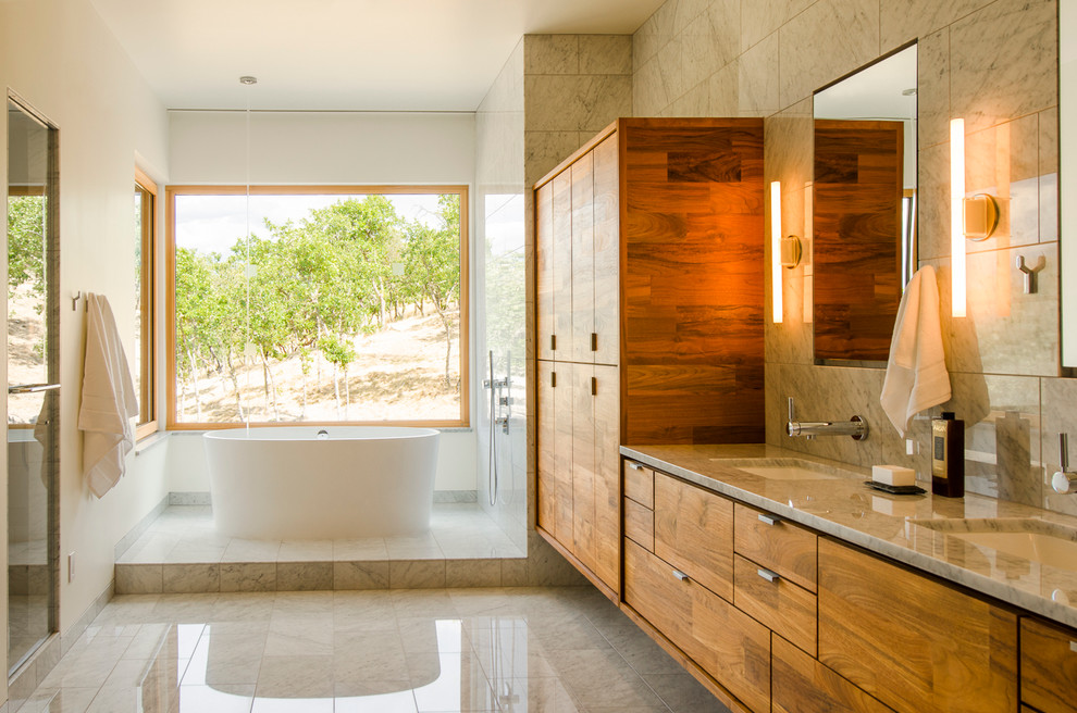 Стильный дизайн: ванная комната в современном стиле с плоскими фасадами, фасадами цвета дерева среднего тона, душем в нише, врезной раковиной, мраморной столешницей, разноцветной плиткой, белыми стенами, мраморным полом и отдельно стоящей ванной - последний тренд