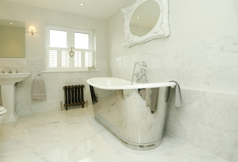 Идея дизайна: детская ванная комната среднего размера в современном стиле с раковиной с пьедесталом, отдельно стоящей ванной, душем над ванной, белой плиткой, каменной плиткой, белыми стенами и мраморным полом