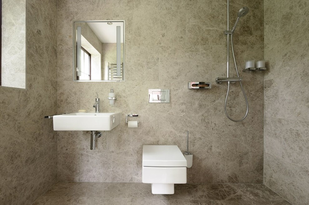 Bild på ett litet funkis badrum med dusch, med ett väggmonterat handfat, en öppen dusch, en vägghängd toalettstol, grå kakel, stenkakel, marmorgolv och med dusch som är öppen