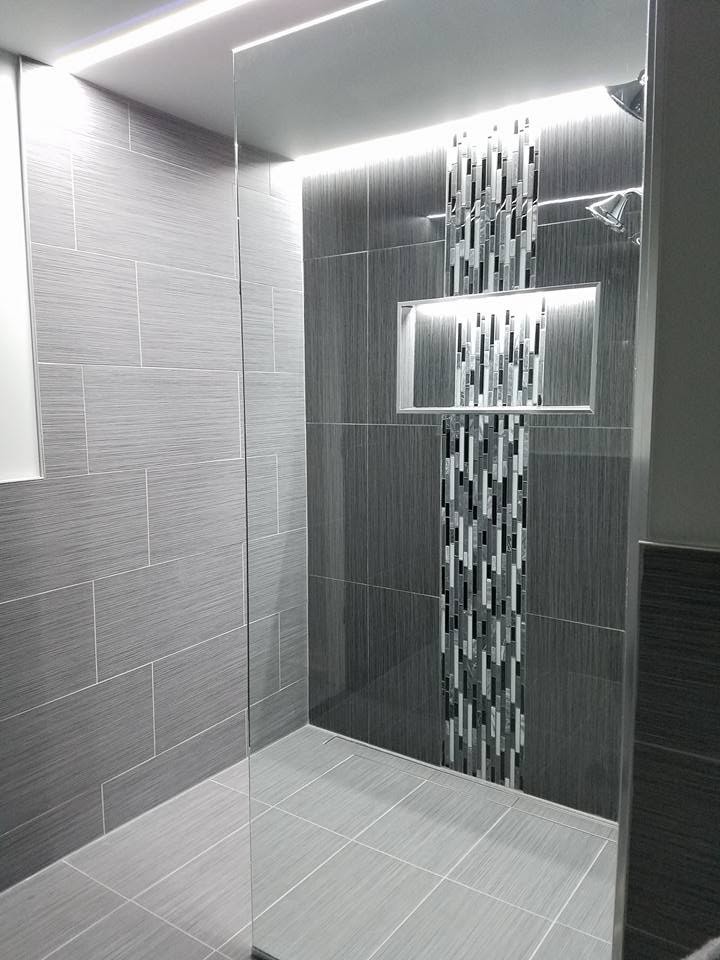 Cette photo montre une salle d'eau tendance de taille moyenne avec une douche d'angle, un carrelage gris, des carreaux de porcelaine, un mur gris, un sol en carrelage de porcelaine, un sol gris et aucune cabine.