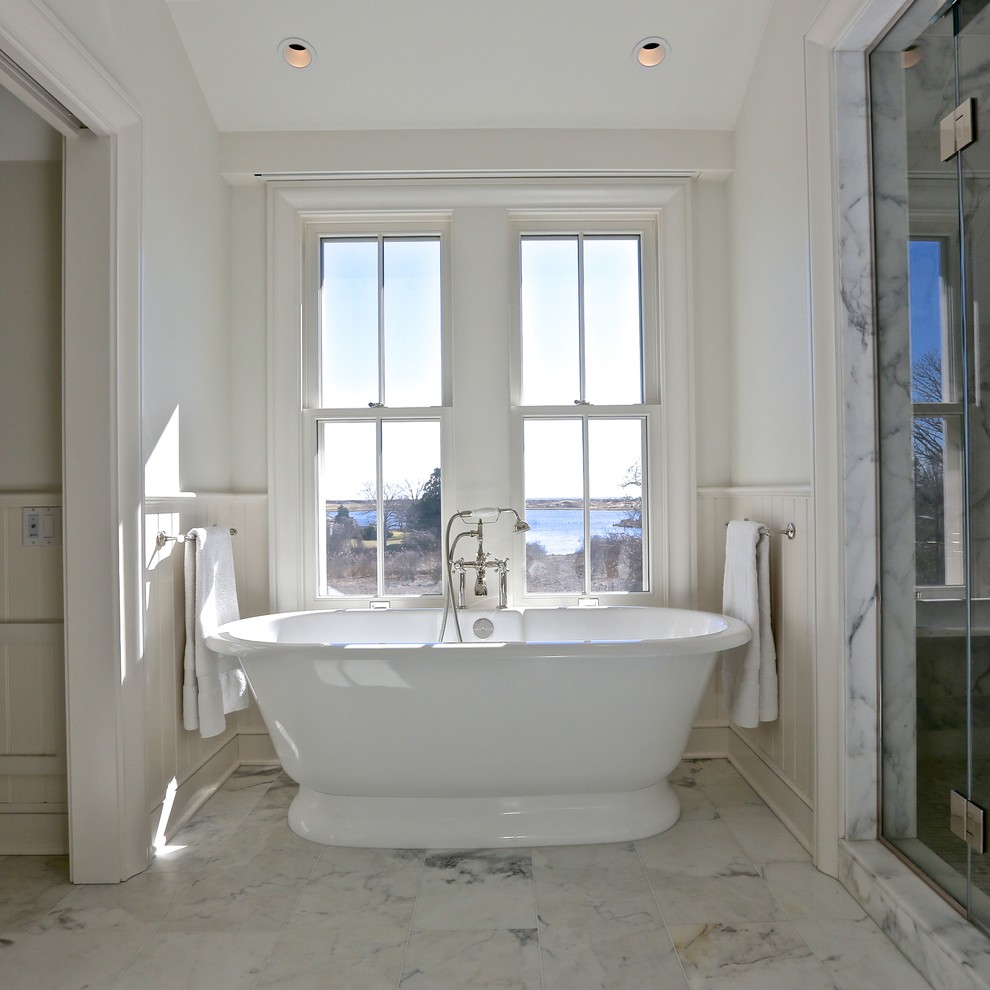 Imagen de cuarto de baño clásico grande con bañera exenta, paredes blancas y suelo de mármol