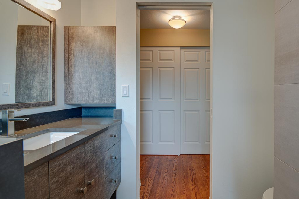 Kleines Modernes Duschbad mit bodengleicher Dusche, Wandtoilette, grauen Fliesen, weißer Wandfarbe, Kiesel-Bodenfliesen, buntem Boden, Schiebetür-Duschabtrennung und grauer Waschtischplatte in Seattle