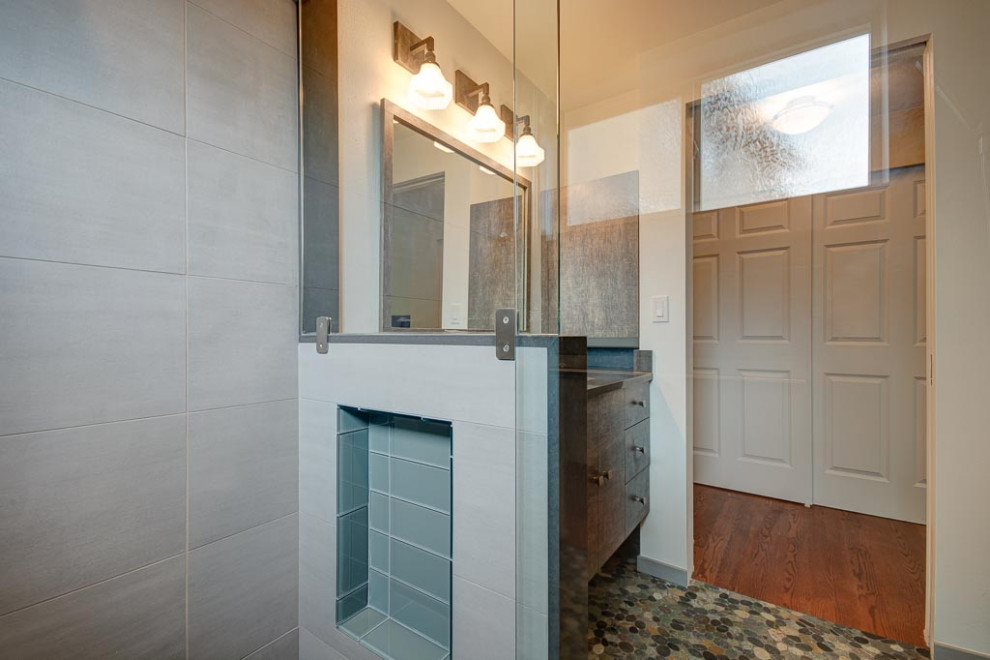 Inspiration för ett litet funkis grå grått badrum med dusch, med en kantlös dusch, en vägghängd toalettstol, grå kakel, vita väggar, klinkergolv i småsten, flerfärgat golv och dusch med skjutdörr