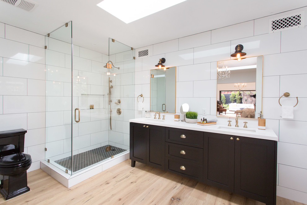 Diseño de cuarto de baño principal campestre con armarios estilo shaker, puertas de armario negras, bañera con patas y baldosas y/o azulejos blancos